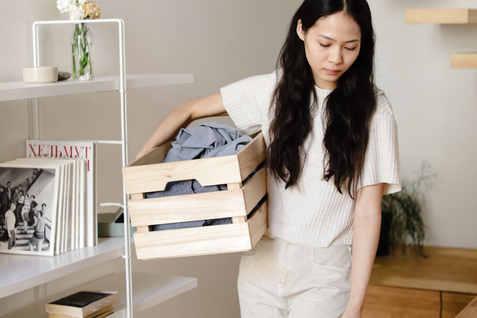 Người phụ nữ châu Á sắp xếp quần áo trong ngôi nhà hiện đại